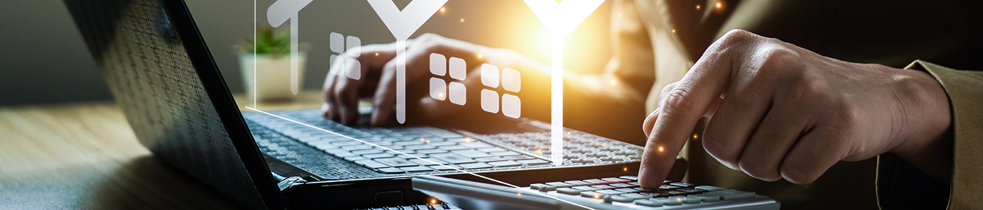 Headerbild Kauf und Verkauf / das Bild zeigt eine Person am Laptop sowie einen Taschenrechner