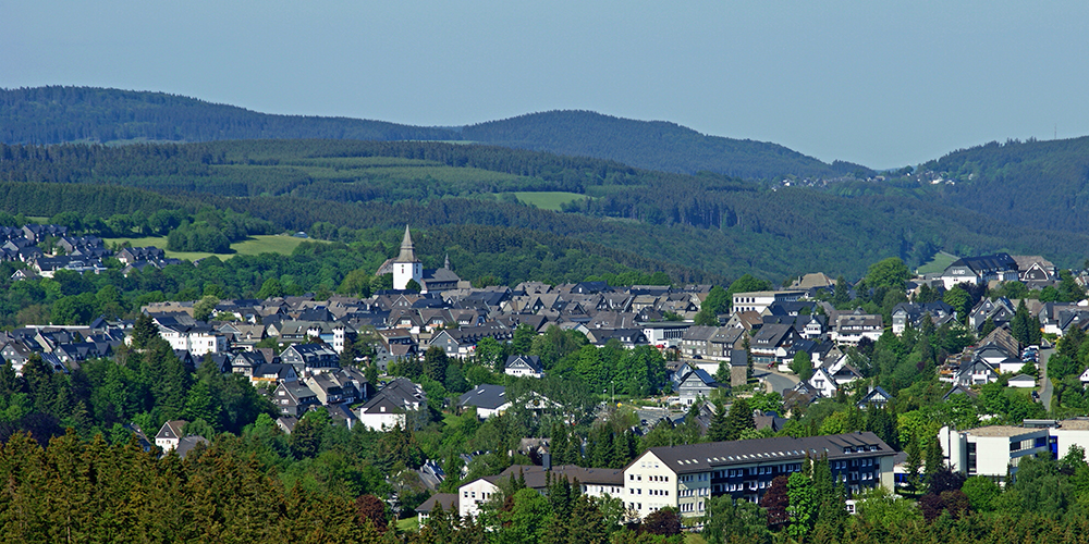 über Grulke Immobilien / das Bild zeigt die Stadt Winterberg mit Bergen im Hintergrund